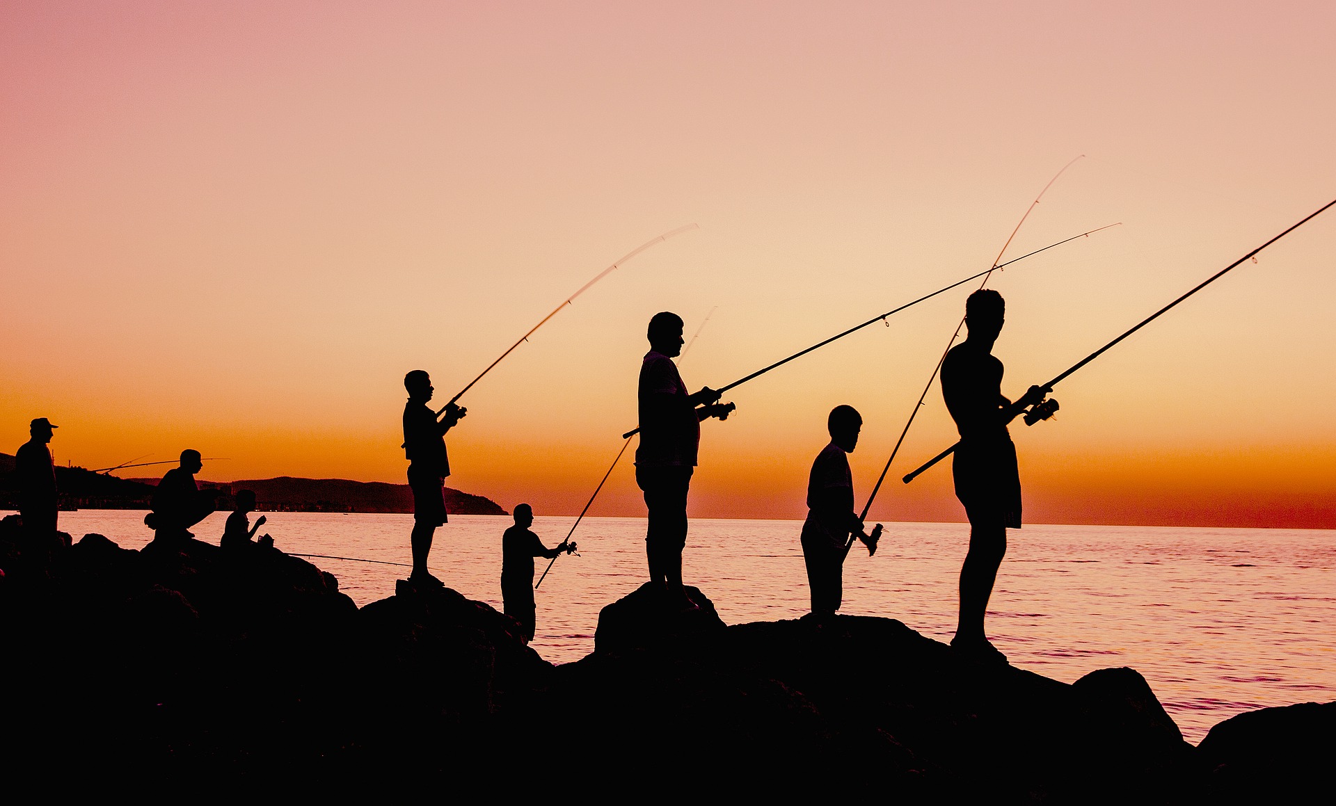A group of people fishing at sunset