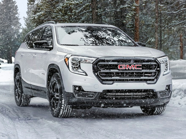 A white GMC car driving in the snow