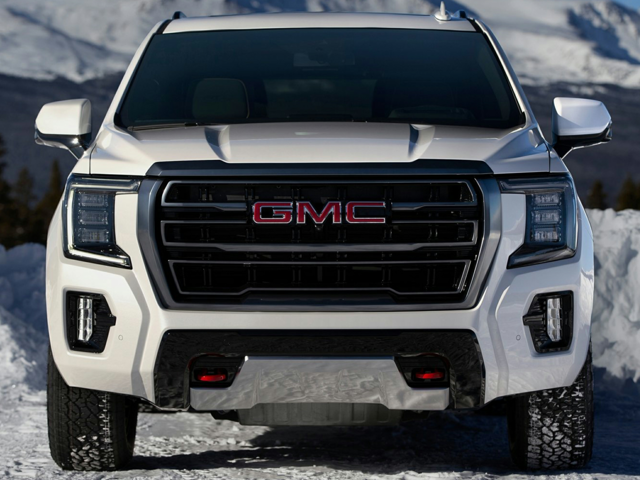 A white GMC Yukon parked outside in the snow